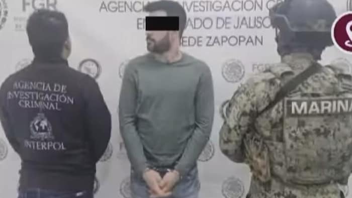 Andrew Clark menotté et debout entre deux policiers mexicains.