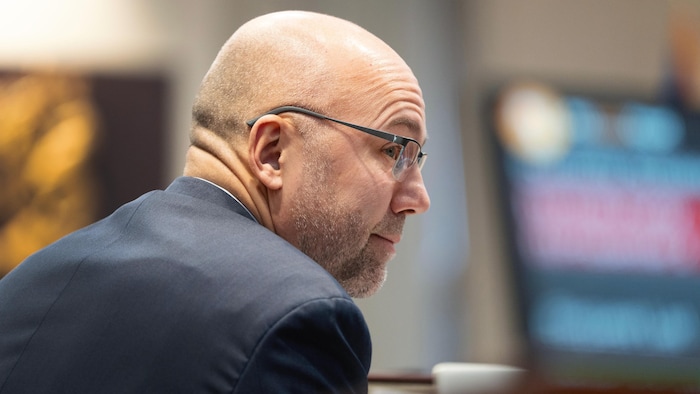 Andy Fillmore, qui est assis et qui porte des lunettes, semble intéressé par ce qui se passe.