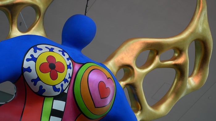 Une sculpture colorée aux ailes dorées.
