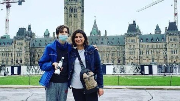 Une photo d'Angela et son fils, debout devant le Parlement à Ottawa.