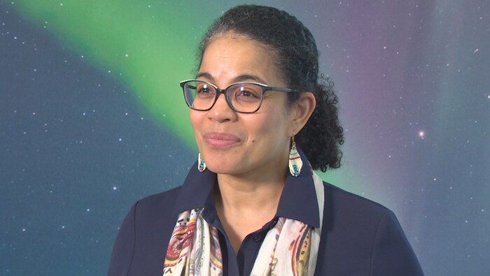 Angela Cassie devant un mur illustrant un aurore boréale. (19 mars 2025)