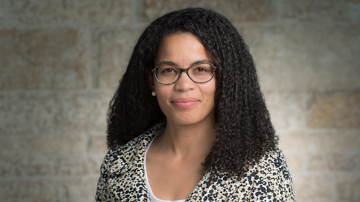 Angela Cassie, vêtue d'un veston texturé, regarde l'objectif en souriant.