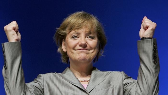 Angela Merkel lève les poings en l'air.