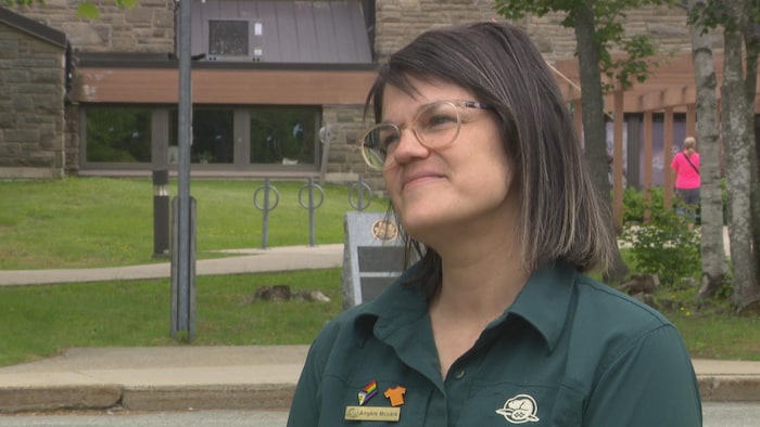 Une femme en entrevue devant le bâtiment d'accueil aux visiteurs du parc national Kouchibouguac.