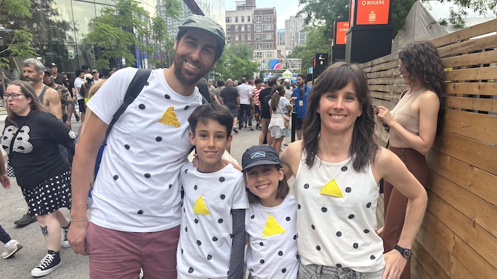 Un père, une mère et leurs deux enfants posent avec des t-shrits à l'effigie du groupe Angine de Poitrine. 
