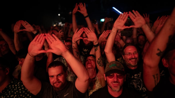 Des amateurs forment un triangle avec leurs mains pendant le spectacle d’Angine de Poitrine au Mod Club de Toronto, le mardi 14 juillet 2026.