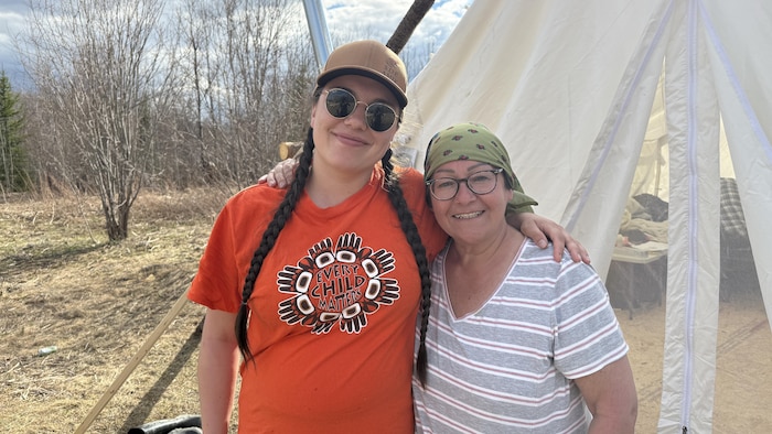 Marie-Soleil Mapachee et Katy Rankinse prennent dans leur bras près d'une tente.