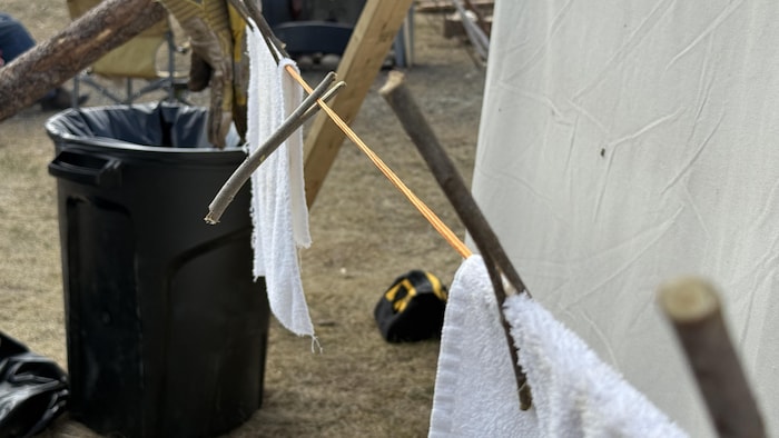 Des épingles à linge artisanales en bois retiennent des serviettes sur une corde.