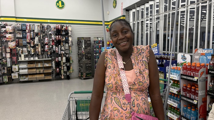 Portrait d'Anita Nopé dans un magasin Dollarama, posant devant un cadis.