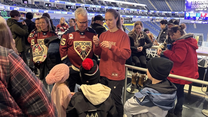 Ann-Renée Desbiens s'empare d'un crayon pour signer un autographe.