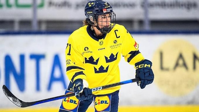 Une joueuse de hockey regarde devant. 