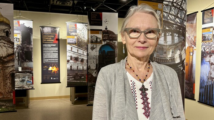 Anna Mycyk est debout devant une exposition de photos, le 23 février 2025 à Saskatoon.
