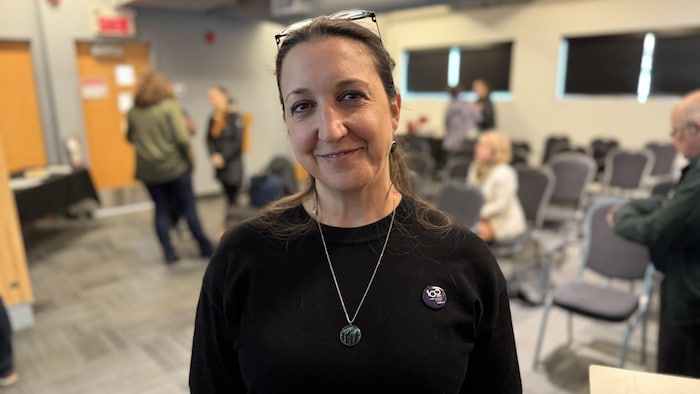 Anne-Frédérique Karsenti pose avec un léger sourire dans une salle où s'est tenue une conférence.