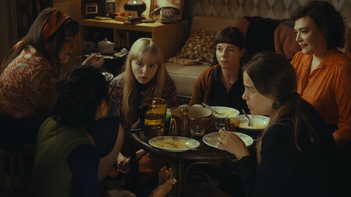 Un groupe de femmes discutent autour d'une table.