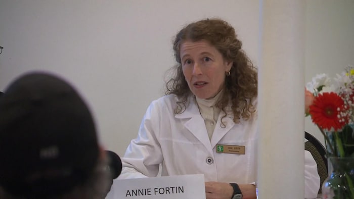 Annie Fortin prend la parole lors de la conférence de presse de Réinfo Covid Québec. Elle porte un sarrau blanc.