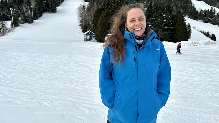 Annie-Joncas en habits d'hiver devant des pistes de ski du Mont-Castor.