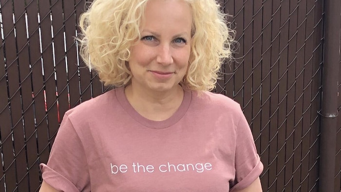 Annie Slight porte un chandail rose sur lequel il est écrit «be the change», ou «sois le changement».