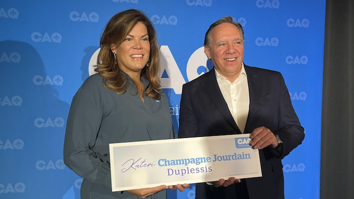 Kateri Champagne Jourdain et François Legault devant le logo de la CAQ.