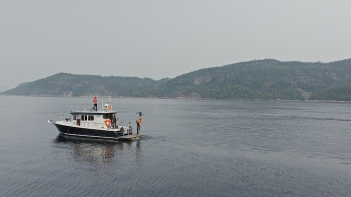 Un bateau de recherche sur lequel se trouvent des scientifiques. Il s'affairent à faire voler un drone. 