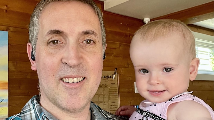 Anthony Bertrand avec un bébé dans les bras.