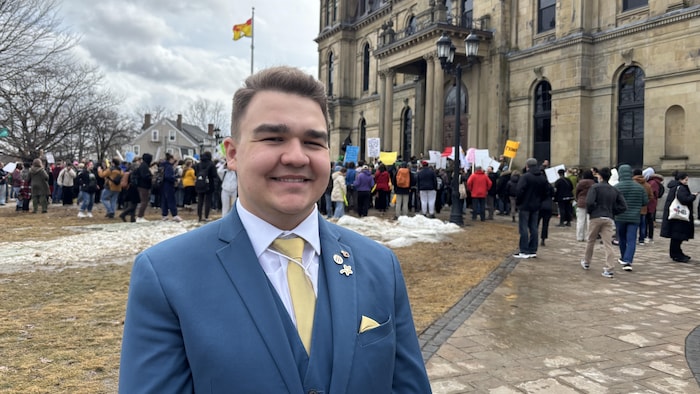 Antoine Chiasson sourit à la caméra, une foule derrière lui.