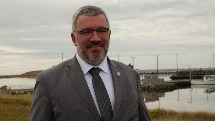 Antonin Valiquette devant le port de l'Étang-du-Nord à l'automne.
