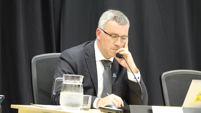 Le maire des Îles-de-la-Madeleine, Antonin Valiquette, assis lors d'une séance du conseil municipal.