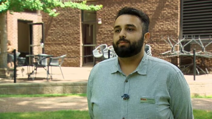 Anubhav Gupta debout dehors en chemise grise.