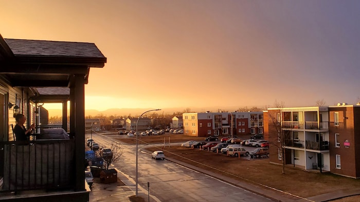Une couche de brume recouvre la rue bordée d'immeubles à logements à Sept-Îles. 