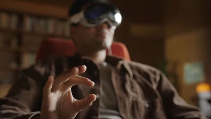Un homme portant un casque de réalité mixte agite les doigts.