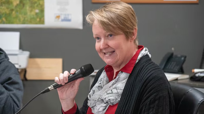 Holly Gauvin s'adresse aux gens, tenant un micro.