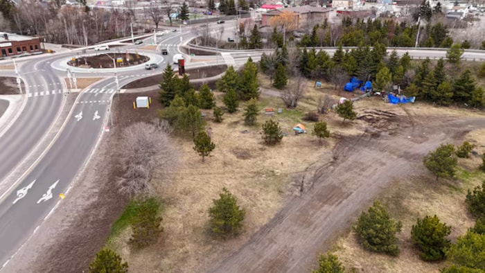 Un campement de sans-abri près d'un rond-point.