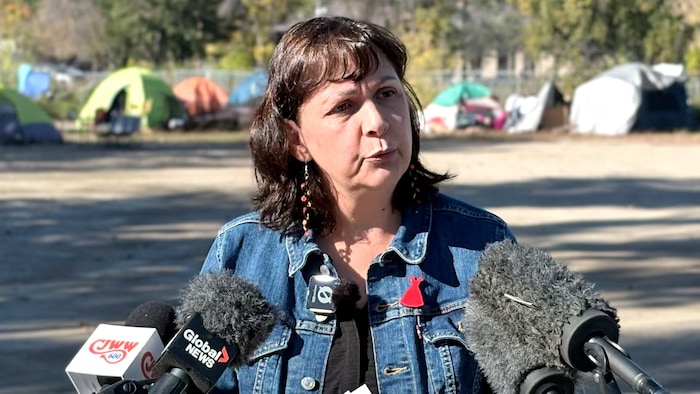 April ChiefCalf, porte-parole néo-démocrate en matière de logement, s'adresse aux journalistes lundi dans un campement installé à Saskatoon.