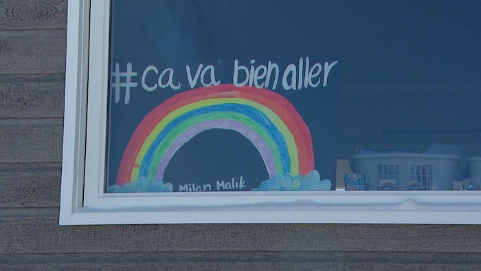Un arc-en-ciel peint sur une fenêtre.