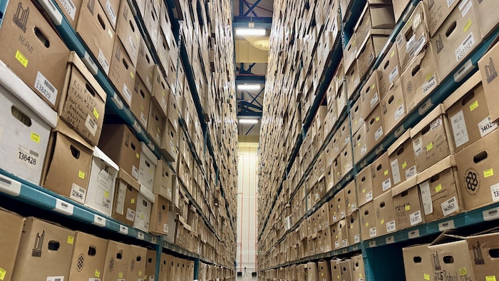 Photo d'une allée pleine de boîtes de documents, aux Archives de Toronto.