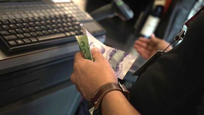 Des billets de banque dans une main.