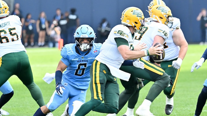 Le défenseur des Argonauts, Branden Dozier, court après le quart-arrière des Elks d'Emonton, Cody Fajardo.
