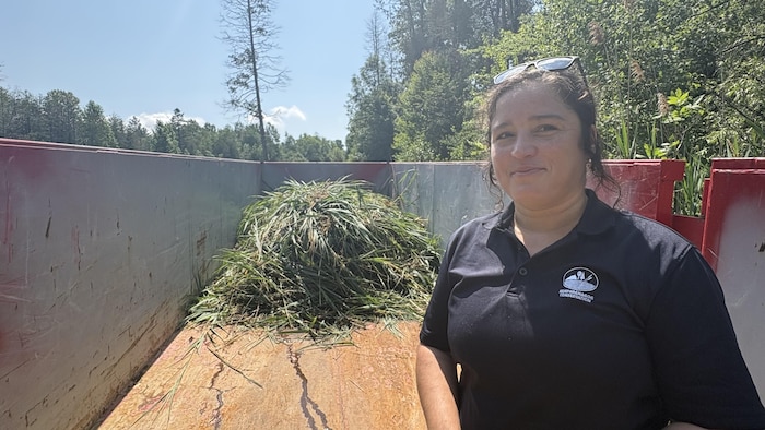 Ariane Orjikh devant une remorque remplie de phragmite.