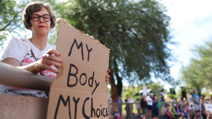 Une femme tient une pancarte sur laquelle on peut lire : « My Body My Choice (Mon corps, mon choix) ».