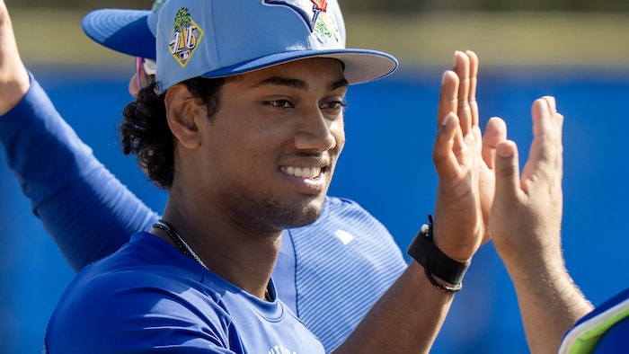 Arjun Nimmala, alors joueur de la formation des Blue Jays de Toronto, tape dans la main d'un coéquipier après une séance d'entraînement printanier à Dunedin, en Floride, le mardi 17 février 2026.