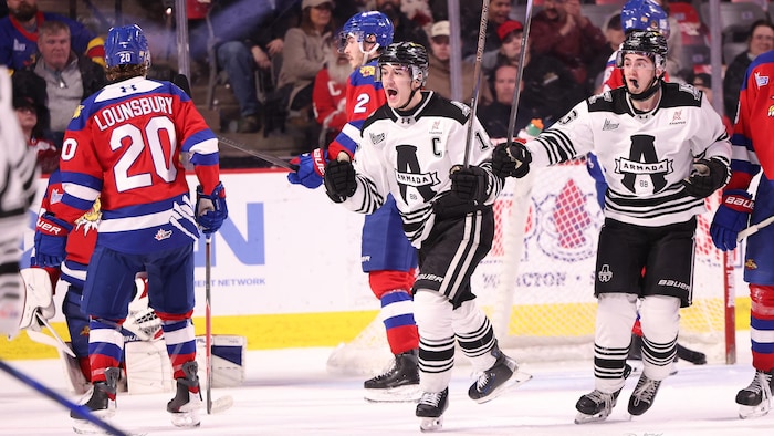 Des joueurs de l'Armada, dont Vincent Collard, célébrant un but sur la glace. 