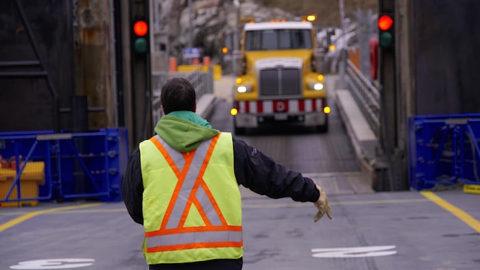 Un employé de la STQ dirige les véhicules sur le traversier Armand-Imbeau II.