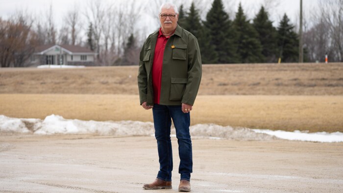 M. Poirier debout dans un parking.