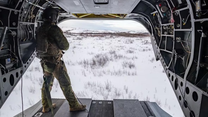 A soldier looks up at the sky. 