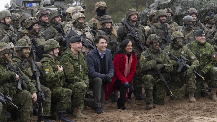 Une photo d'archives datant de mars 2022 montre M. Trudeau et Mme Anand accroupis sur un genou avec des militaires canadiens. 
