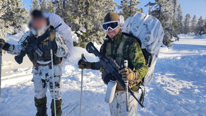 Jérémie Legault et un autre soldat ont des skis au pied, dans un décor hivernal.
