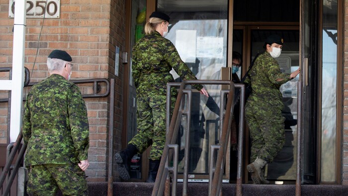 Trois soldats dans l'entrée de la résidence.