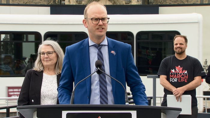 Le député conservateur Arnold Viersen au micro, avec sa collègue Cathy Waganthall en arrière-plan et le porte-parole de la «Marche pour la vie». 