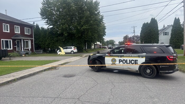 Une voiture de police qui surveille un périmètre de sécurité. 