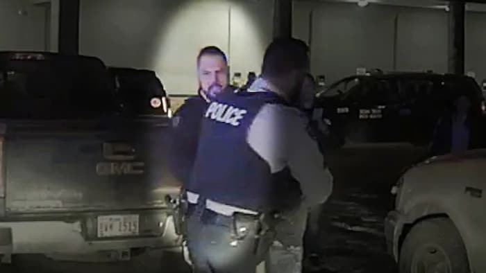 Un policier derrière un collègue lors d'une arrestation.